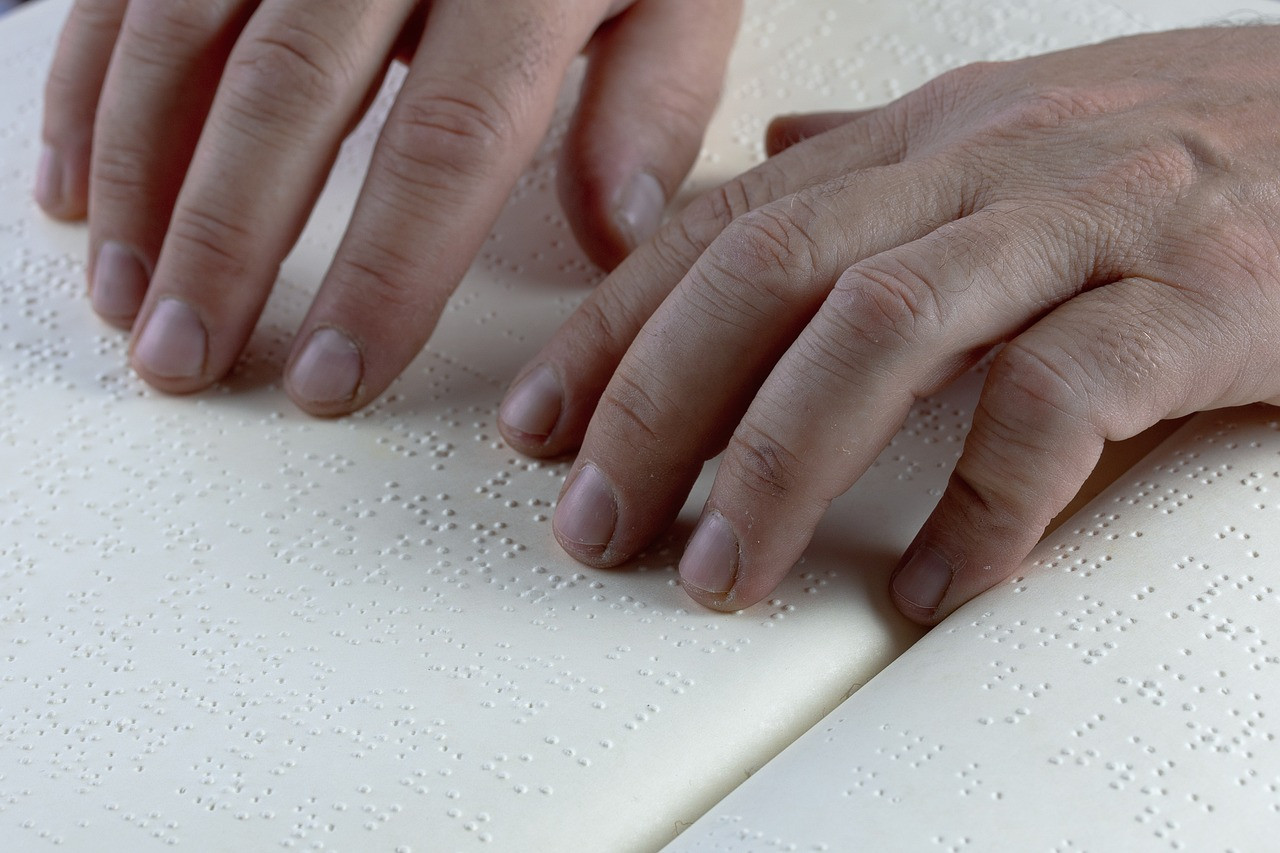 Representative image: braille book fingers reading