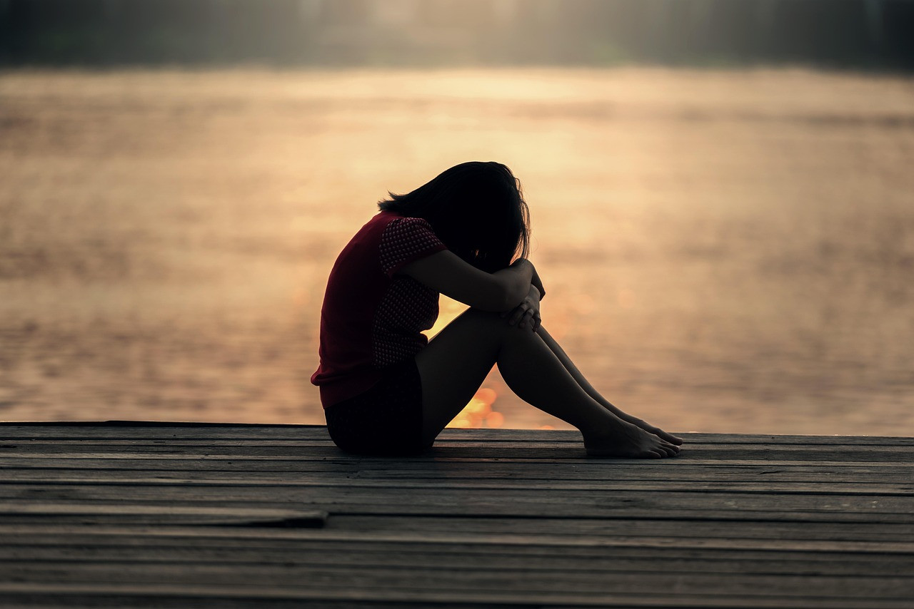 Representative image: woman sitting alone by window