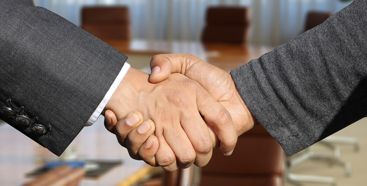 Representative image: handshake business suits