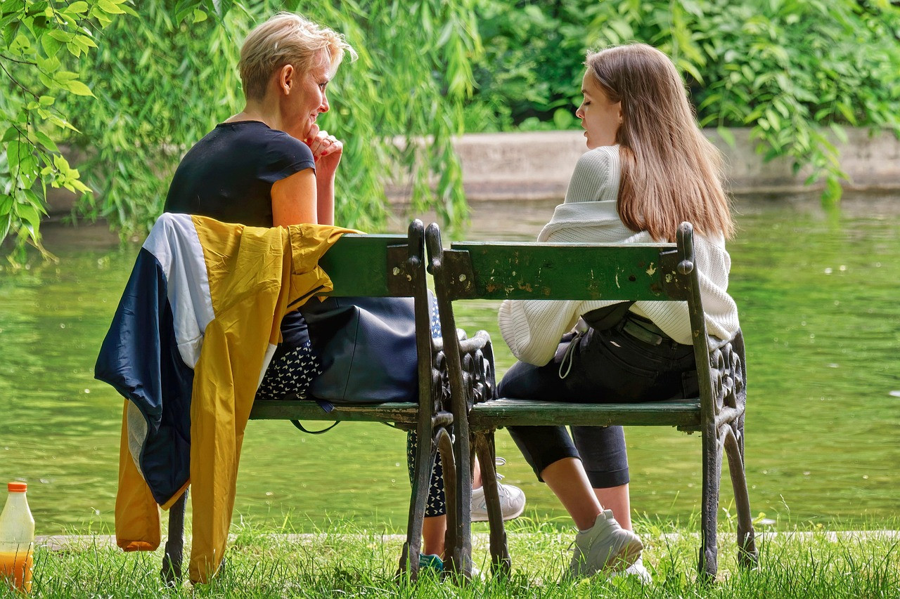 Representative image: young people talking on park bench